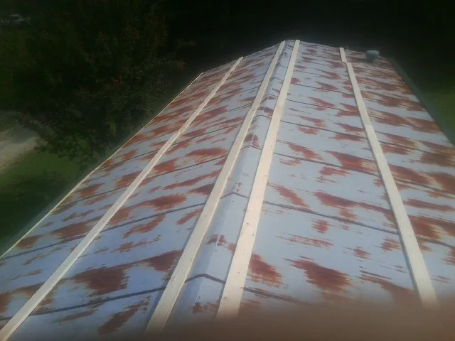 Rusted metal roof panels with new wood purlins before replacement — Storm Damage Roof Repair in La Vergne by Roofing Brothers