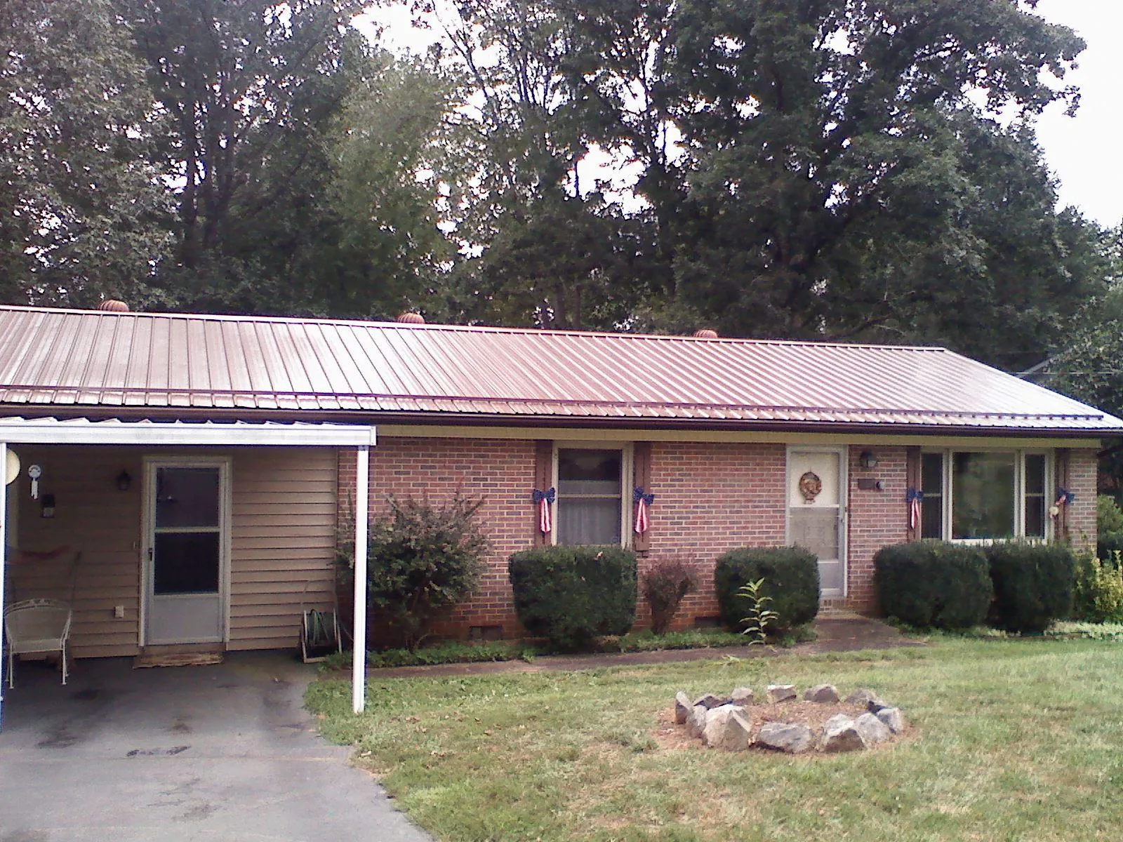 Bronze metal roof and carport on a brick ranch home — Roof Repair work by our crew in La Vergne